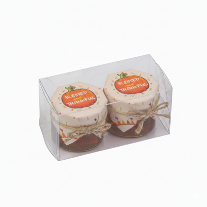 Two small jars with 'Blessed' and 'Thankful' labels in a clear packaging box on a white background.