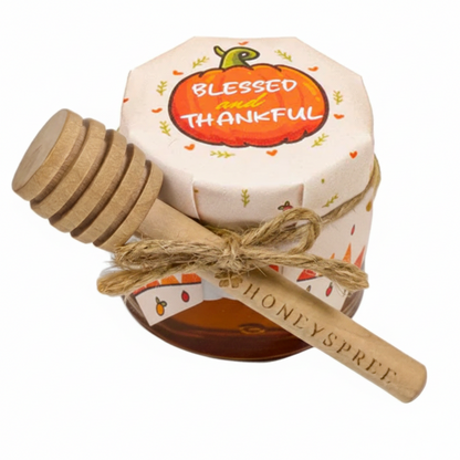 Honey container with wooden dipper featuring 'Blessed and Thankful' text on a white background