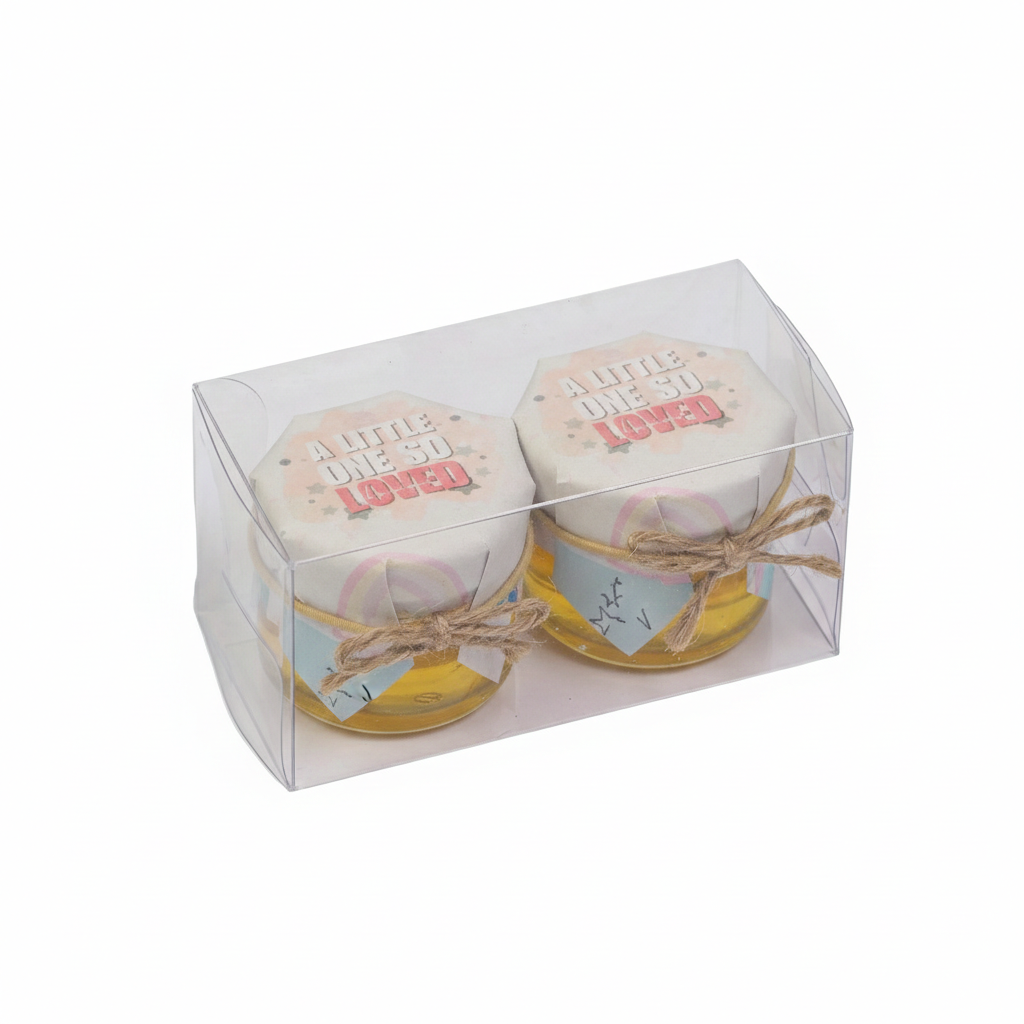Two small jars with decorative labels in a clear packaging box on a white background