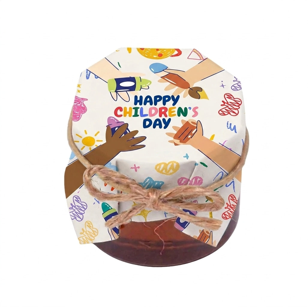 Small honey jar gift wrapped in colorful Happy Children's Day packaging with children's hand illustrations and a twine bow.
