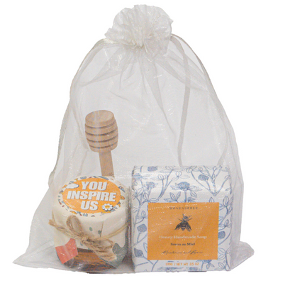 A set of gift items including a honey jar, a handmade soap, and an organza bag, packaged together.