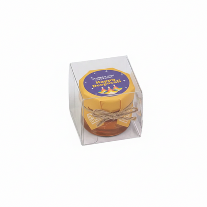 Small round gift item in a clear box with a 'Happy Diwali!' label on a white background