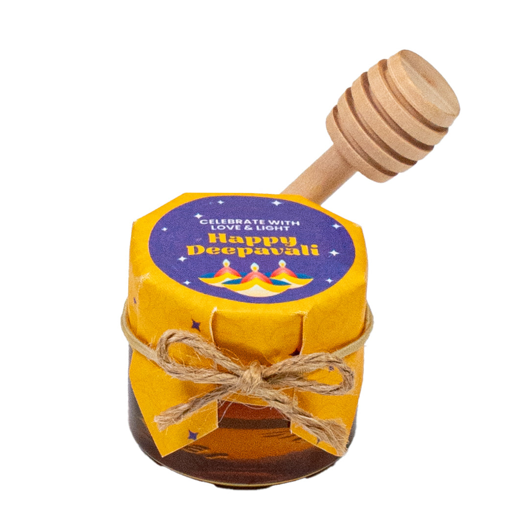 Jar of honey with a wooden dipper and 'Happy Deepavali' label on a white background