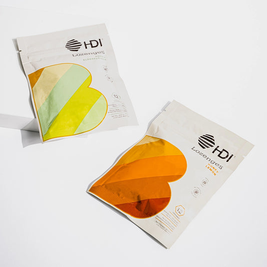 Two packages of HDI lozenges with heart-shaped designs on a white background